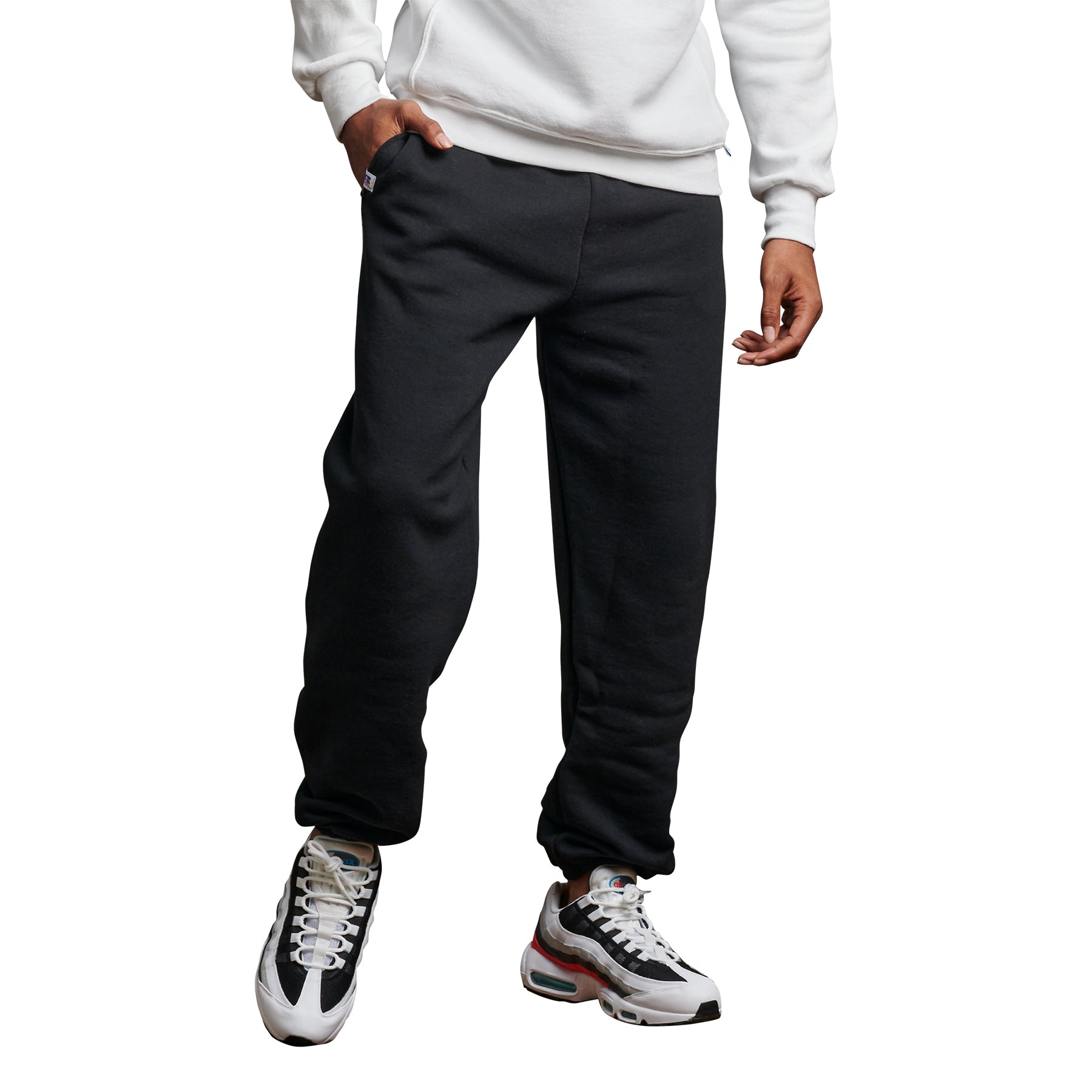 Russell Athletic DRI-POWER adult black sweatpants with pockets and a closed-bottom hem worn with a white hoodie.