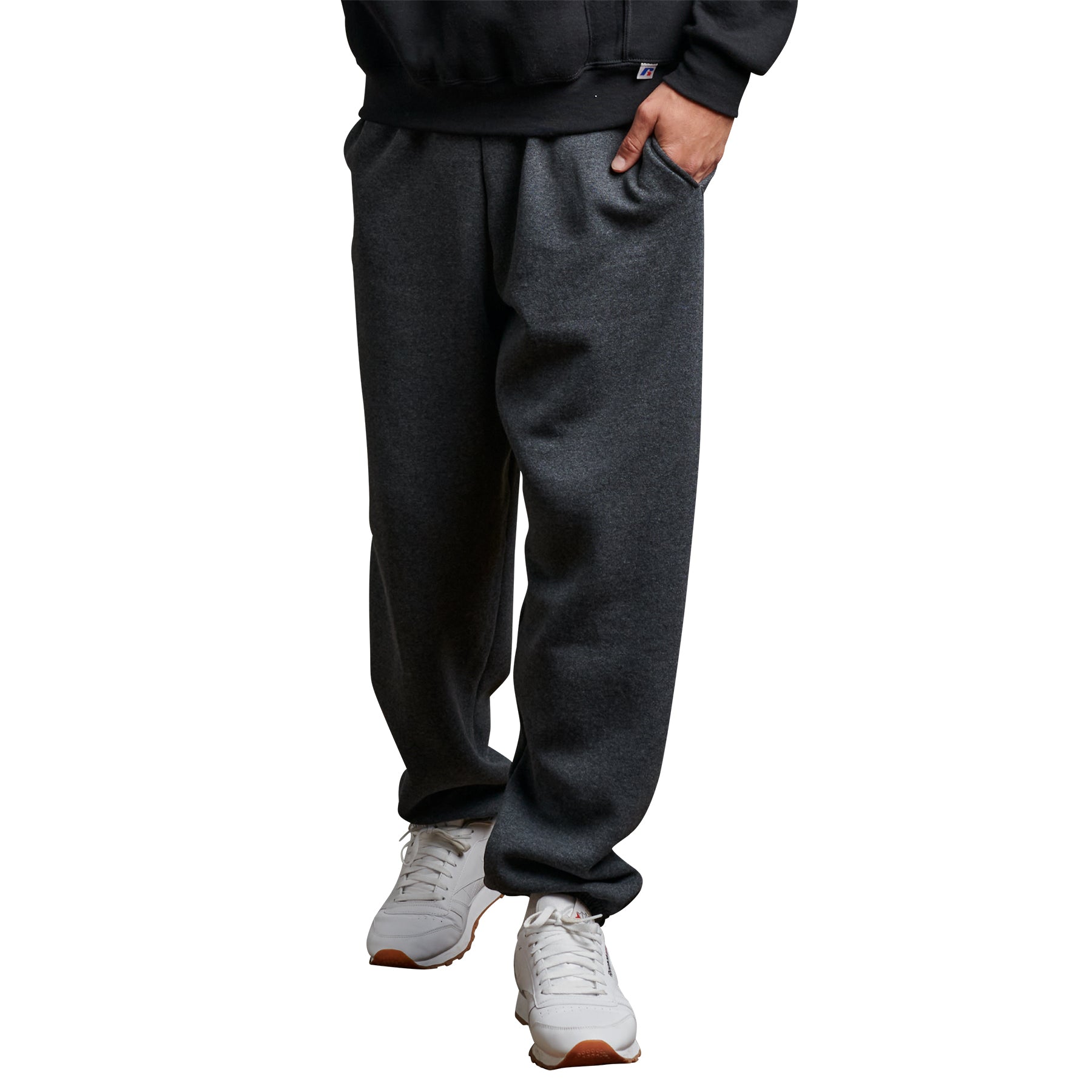 Russell Athletic DRI-POWER adult closed-bottom sweatpants in black heather worn with white sneakers.