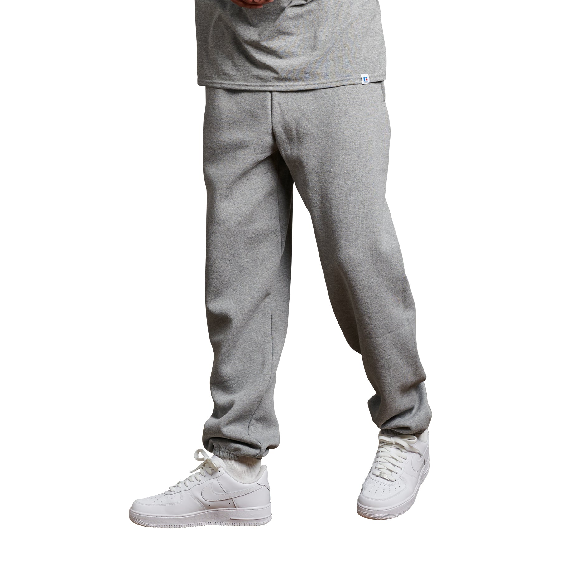 Russell Athletic DRI-POWER® adult closed-bottom pocket sweatpants in Oxford gray worn with white sneakers.