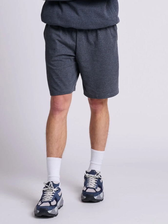 Russell Athletic Cotton Jersey Pocketed Short in black heather worn with white socks and navy athletic sneakers.