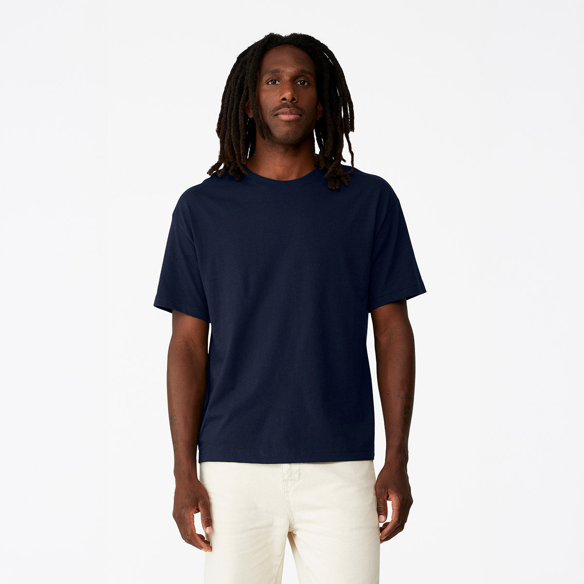 A model wearing a navy Bella + Canvas Unisex 6 oz Heavyweight Tee against a white background.