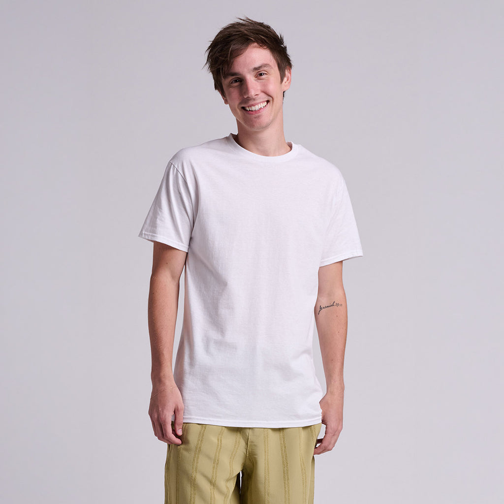 Man smiling while wearing a white Jerzees Classics Unisex T-Shirt against a grey background.