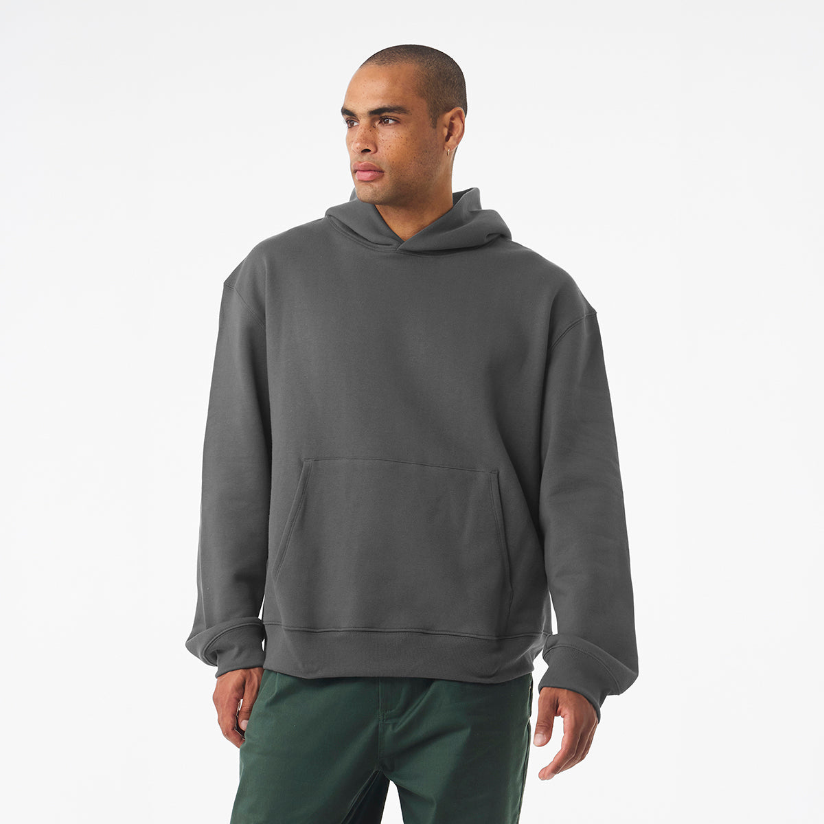 A man wearing a Bella + Canvas Unisex 10 oz Heavyweight Pullover Hoodie in Asphalt.