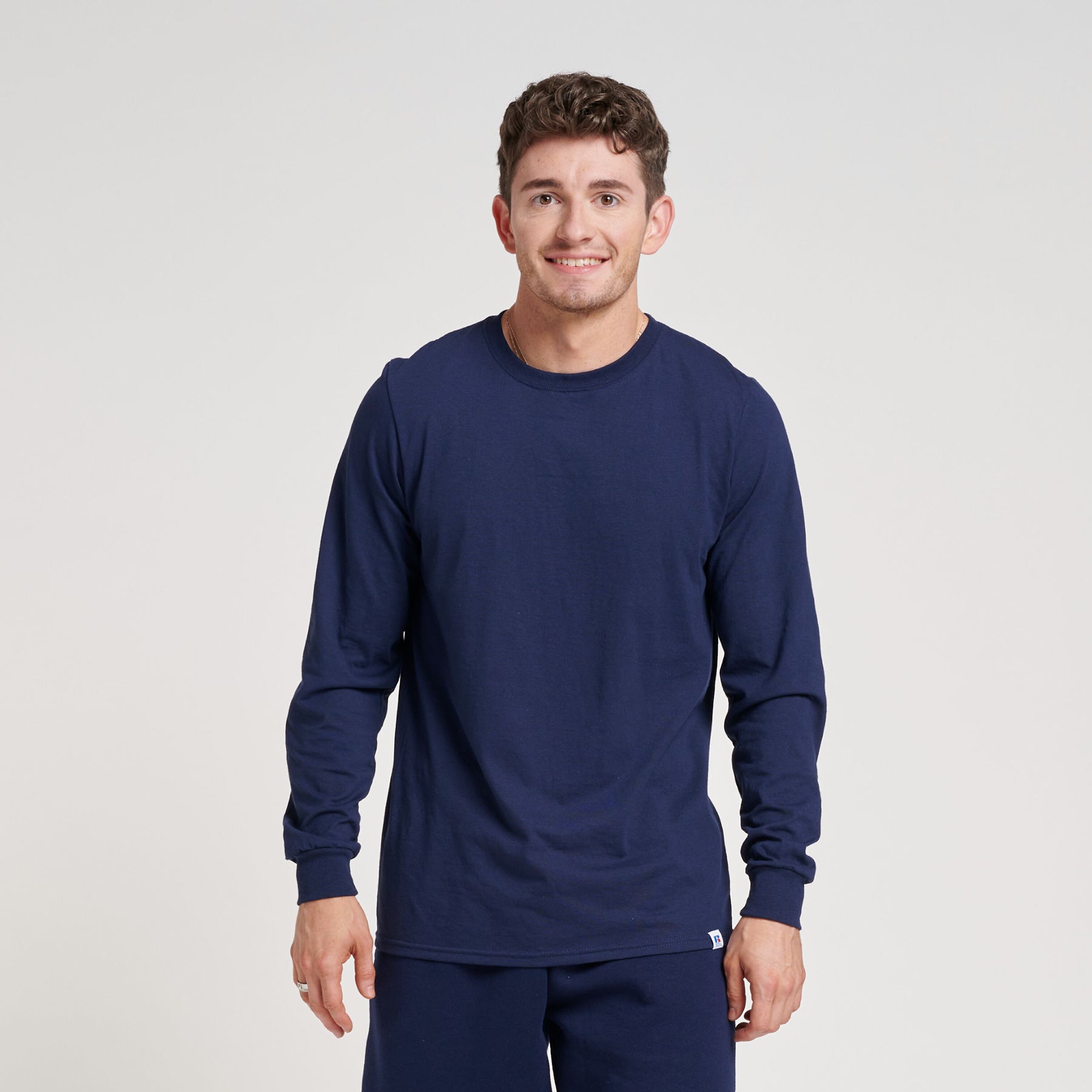 Model wearing a navy Russell Athletic DRI-POWER CVC Performance unisex long-sleeve T-shirt.