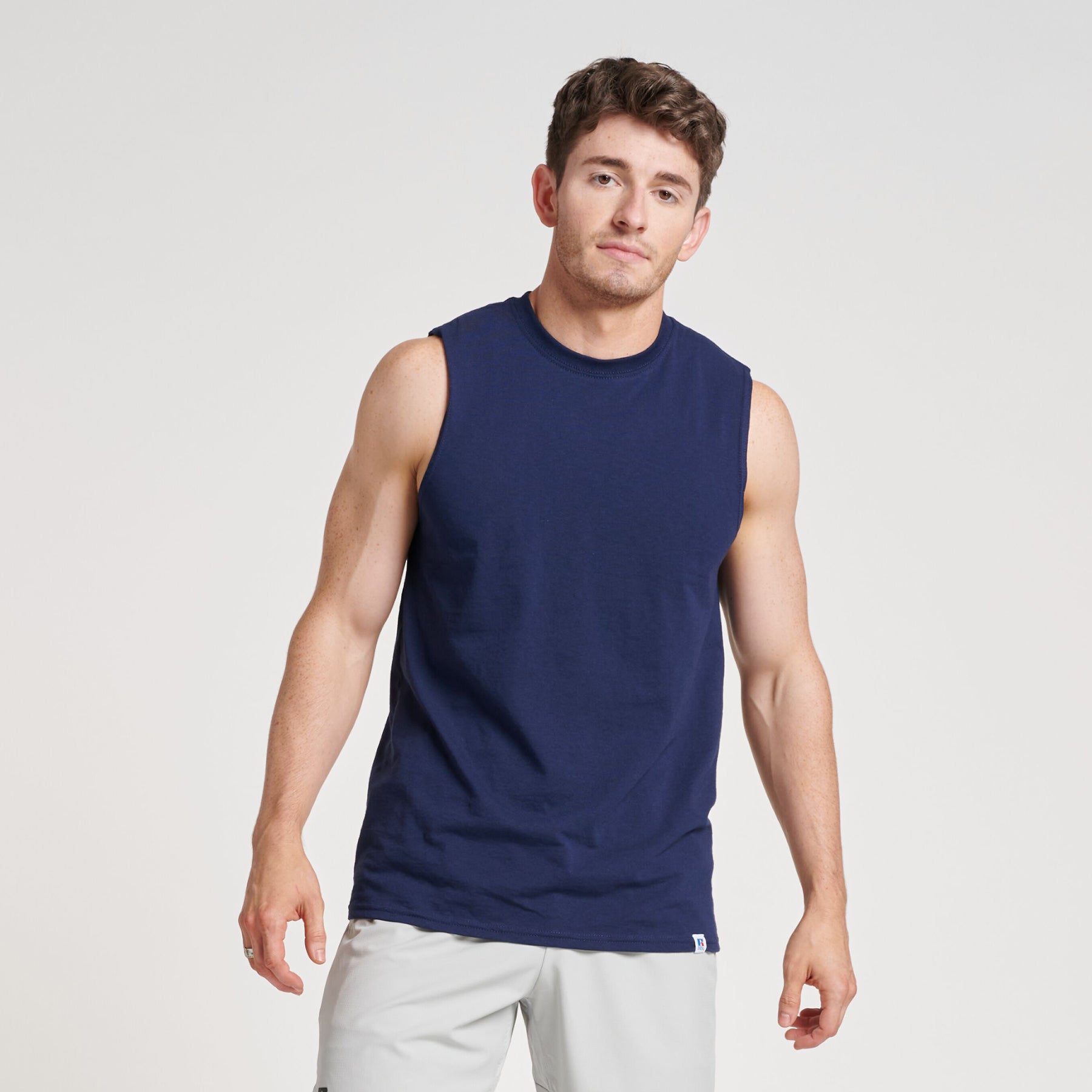 Russell Athletic DRI-POWER CVC Performance unisex muscle t-shirt in navy, worn by a man against a white background.
