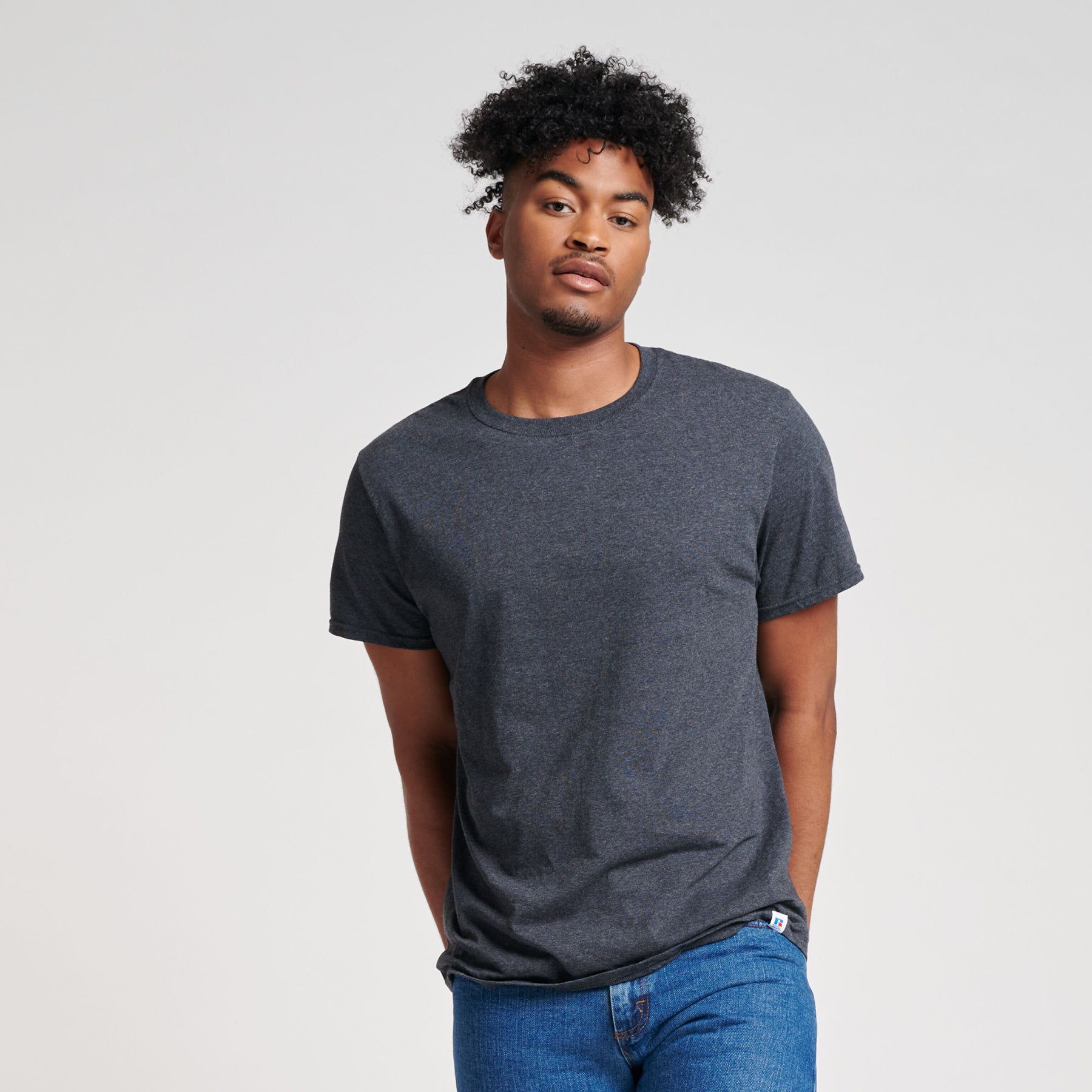 Russell Athletic DRI-POWER CVC Performance unisex T-shirt in black heather worn by a man with curly hair.