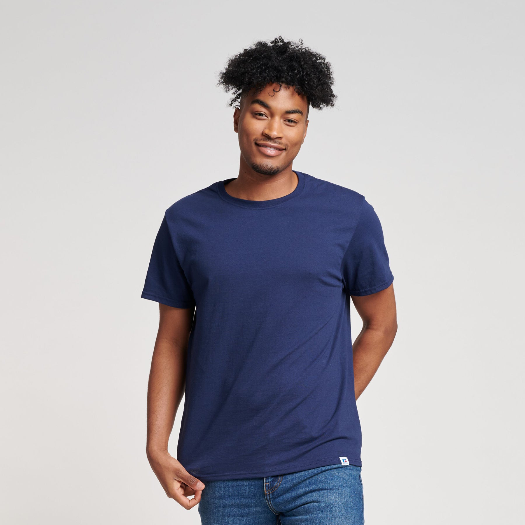 A model wearing a navy Russell Athletic DRI-POWER CVC Performance unisex short-sleeve T-shirt.