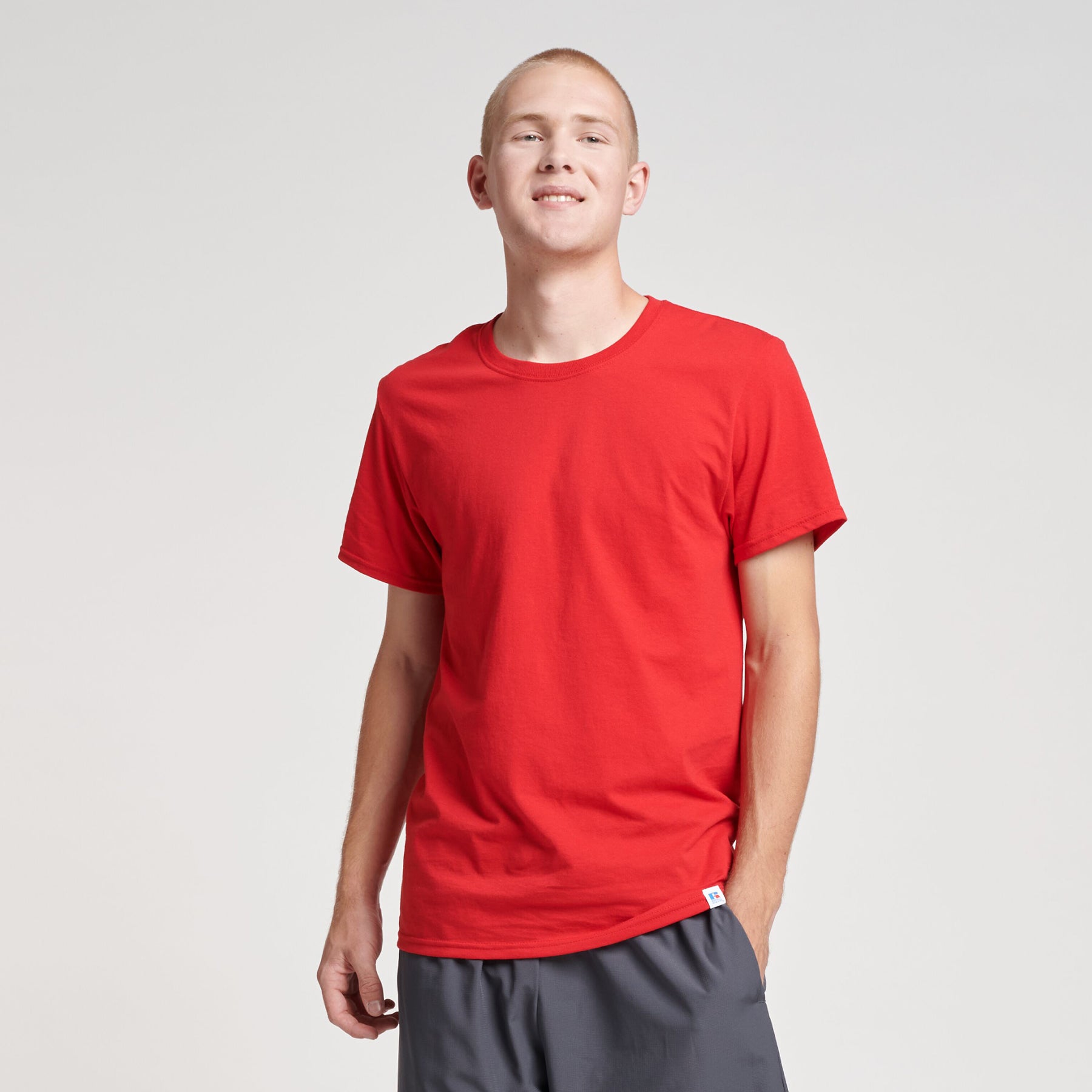 A man wearing a Russell Athletic DRI-POWER CVC Performance unisex short-sleeve t-shirt in True Red.