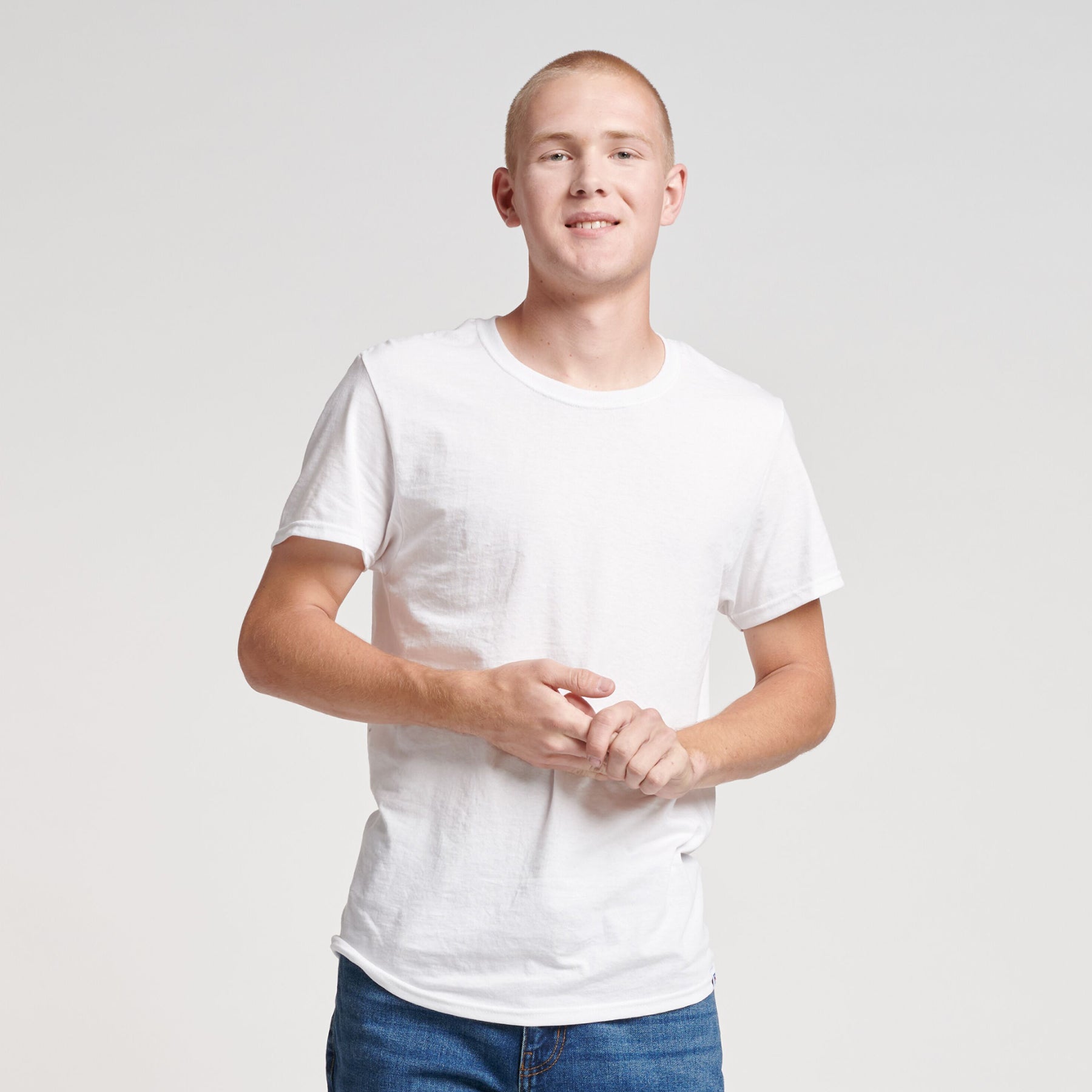 Young man wearing a white Russell Athletic DRI-POWER CVC Performance unisex short-sleeve T-shirt.