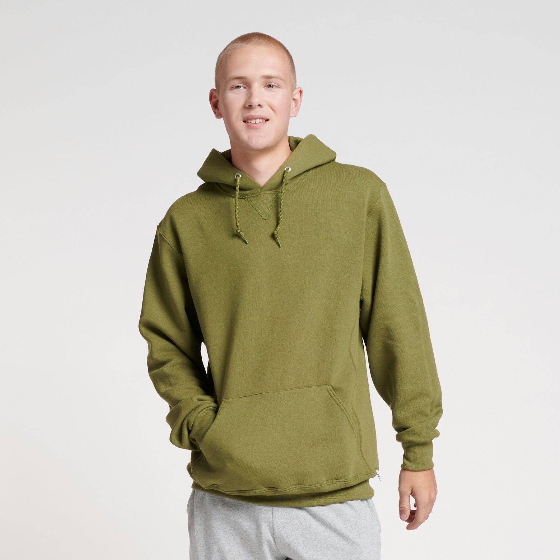 A man wearing a Green Moss Russell Athletic DRI-POWER Adult Fleece Unisex Hoodie against a white background.