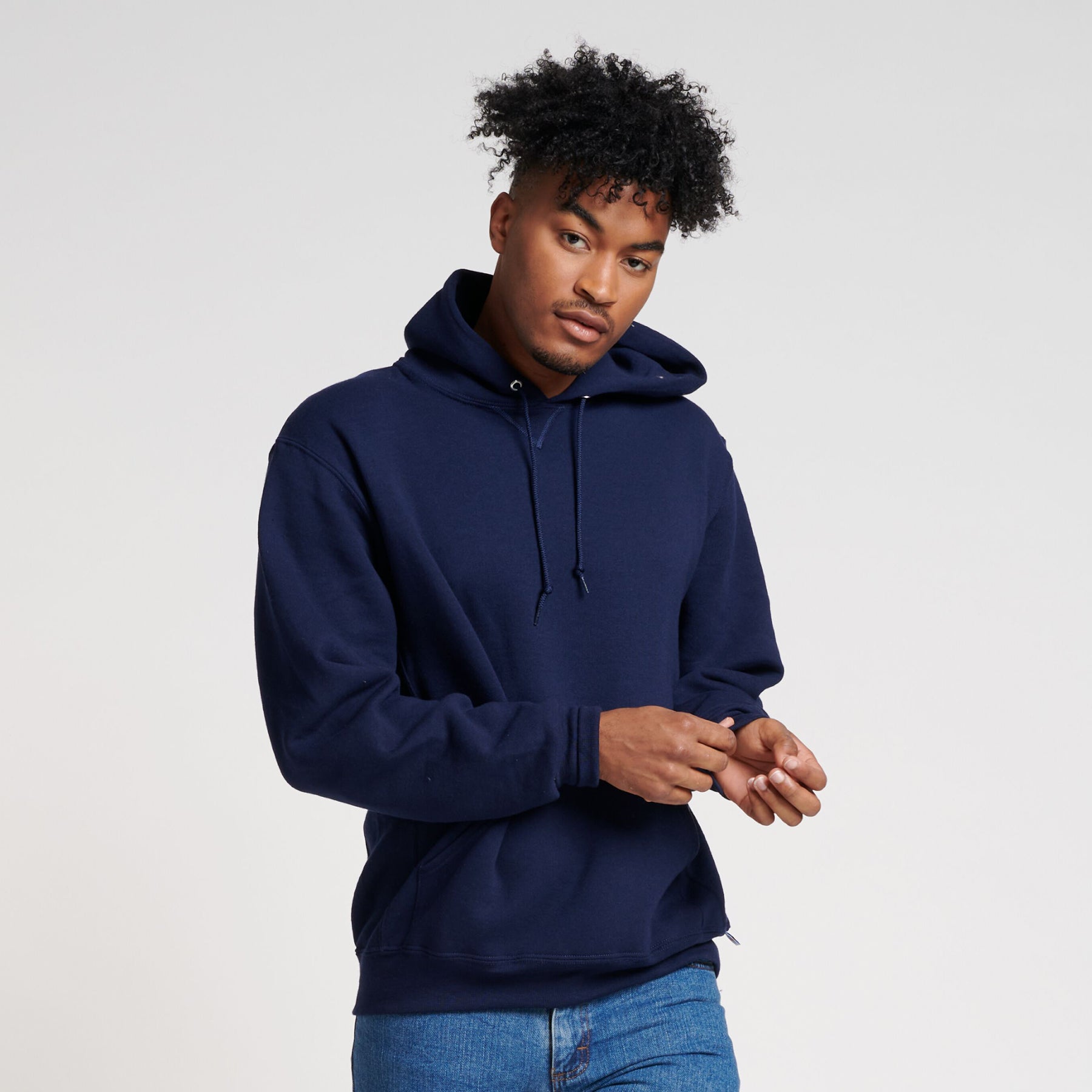 A man wearing a navy Russell Athletic DRI-POWER Adult Fleece Unisex Hoodie against a white background.