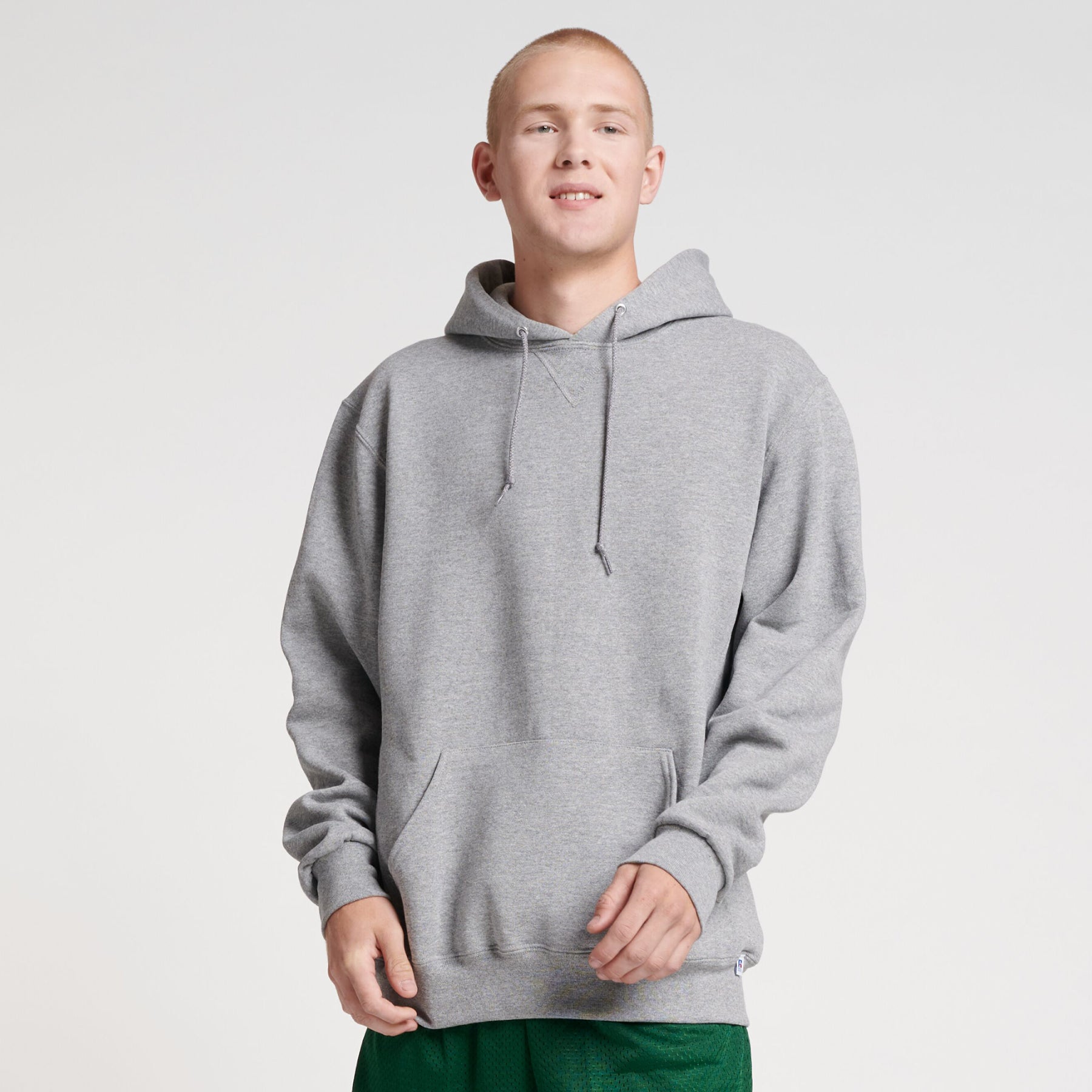 A man wearing a grey Russell Athletic DRI-POWER Adult Fleece Unisex Hoodie in Oxford color.