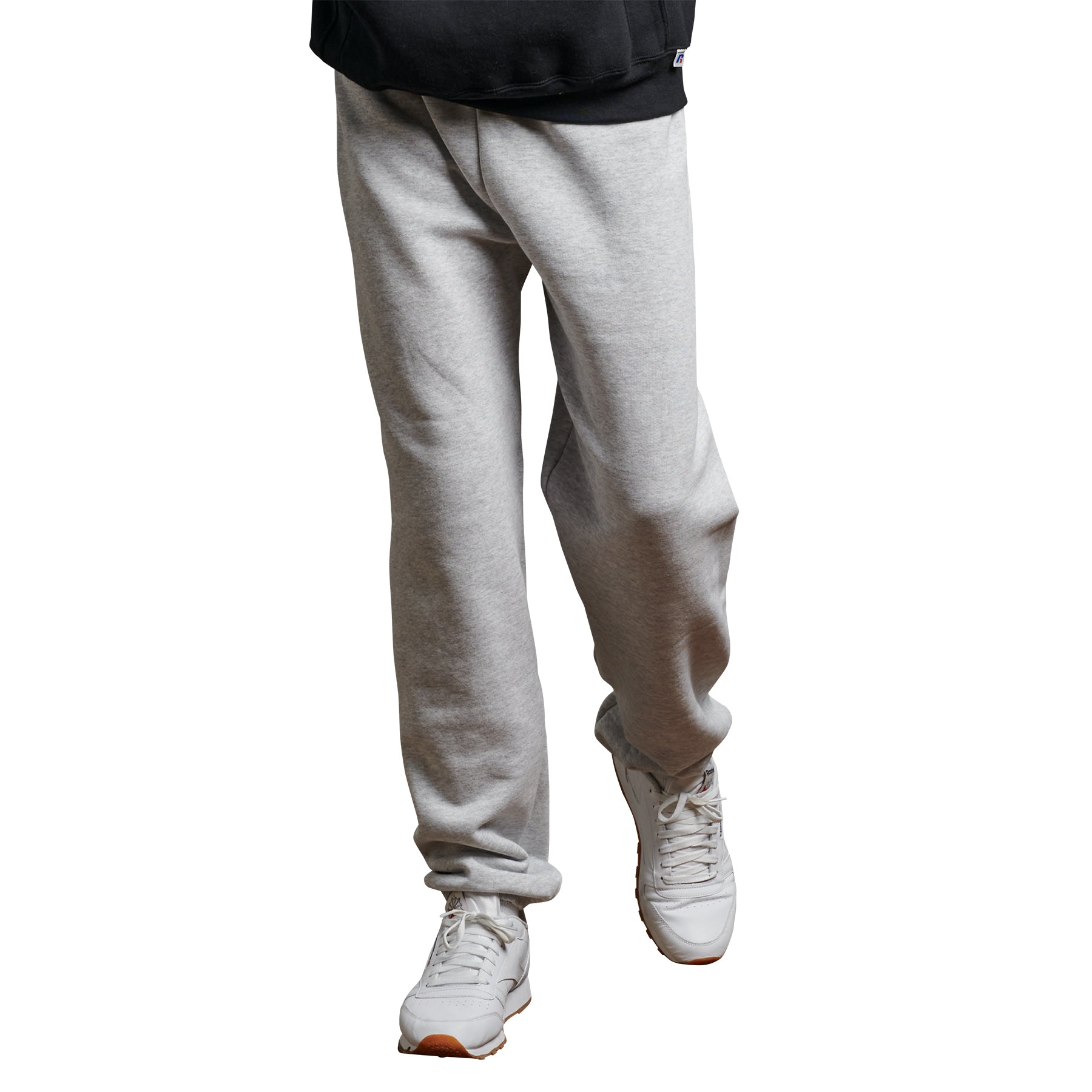 Russell Athletic DRI-POWER adult closed-bottom sweatpants in ash grey, worn with white sneakers.