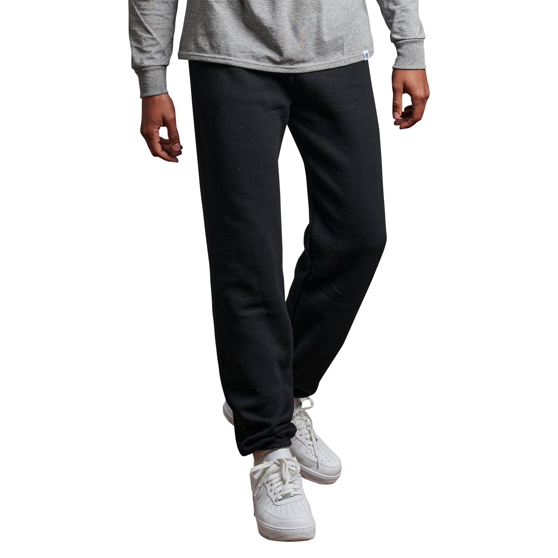 Russell Athletic DRI-POWER adult black closed-bottom sweatpants worn with a grey long-sleeve shirt and white sneakers.