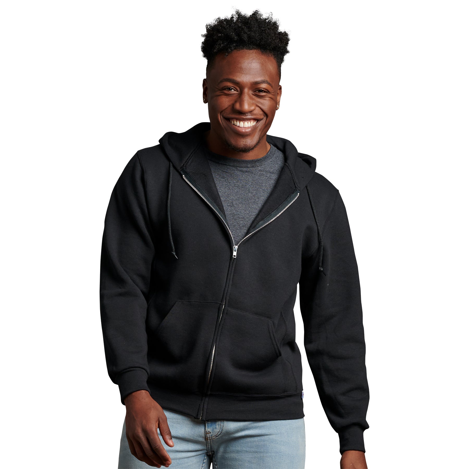 A smiling man wearing a black Russell Athletic DRI-POWER Adult Fleece Full-Zip Hoodie over a grey shirt.