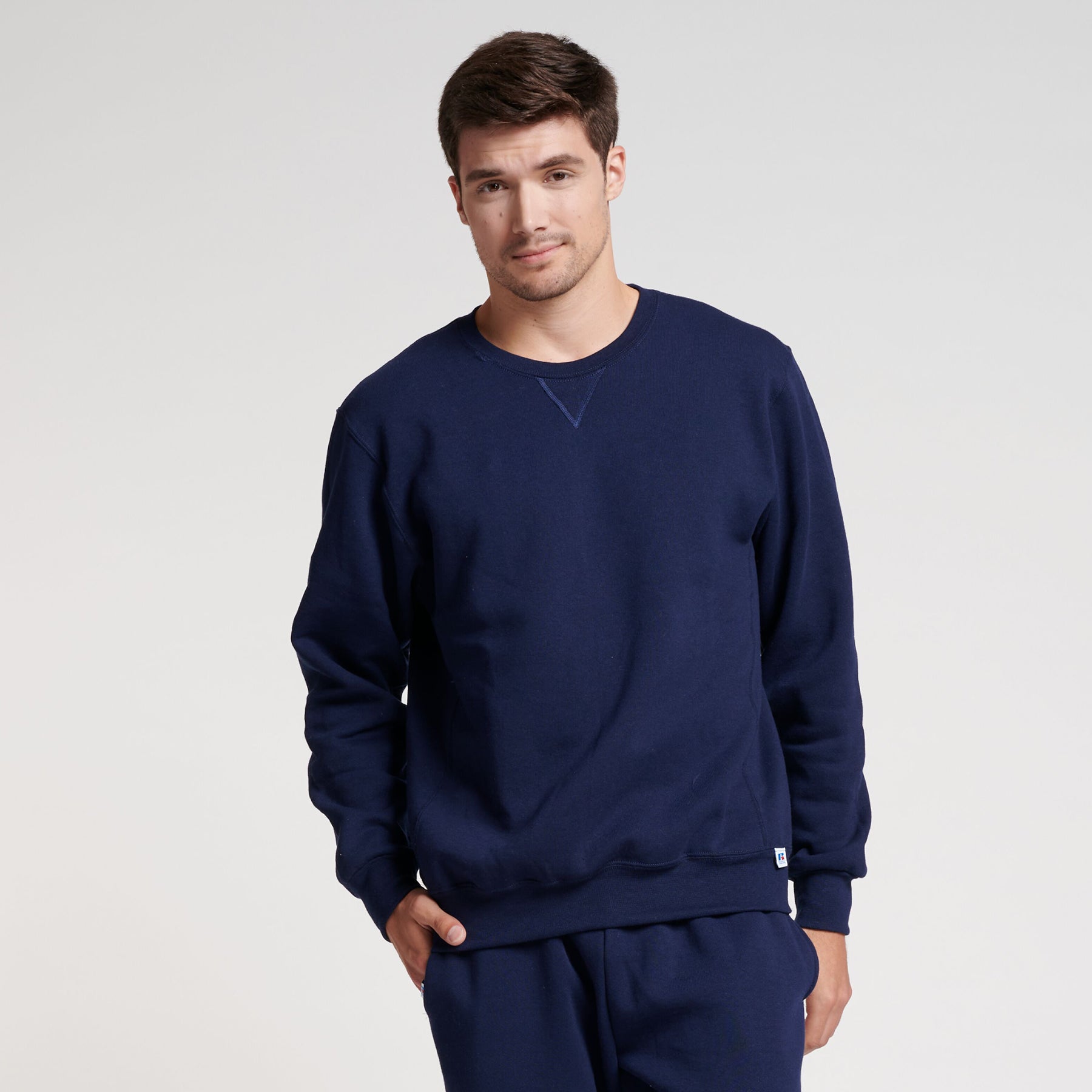 Model wearing a navy blue Russell Athletic DRI-POWER Adult Fleece Crew sweatshirt.