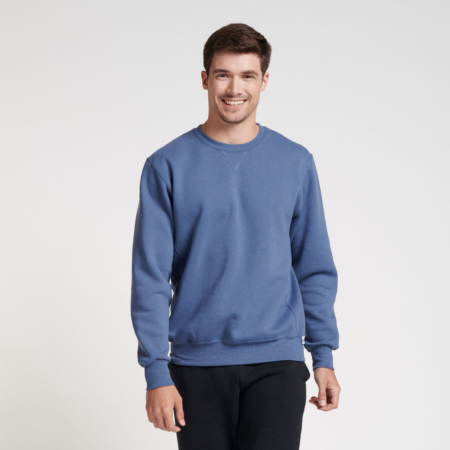 A model wearing a Russell Athletic DRI-POWER Adult Fleece Crew sweatshirt in vintage blue.