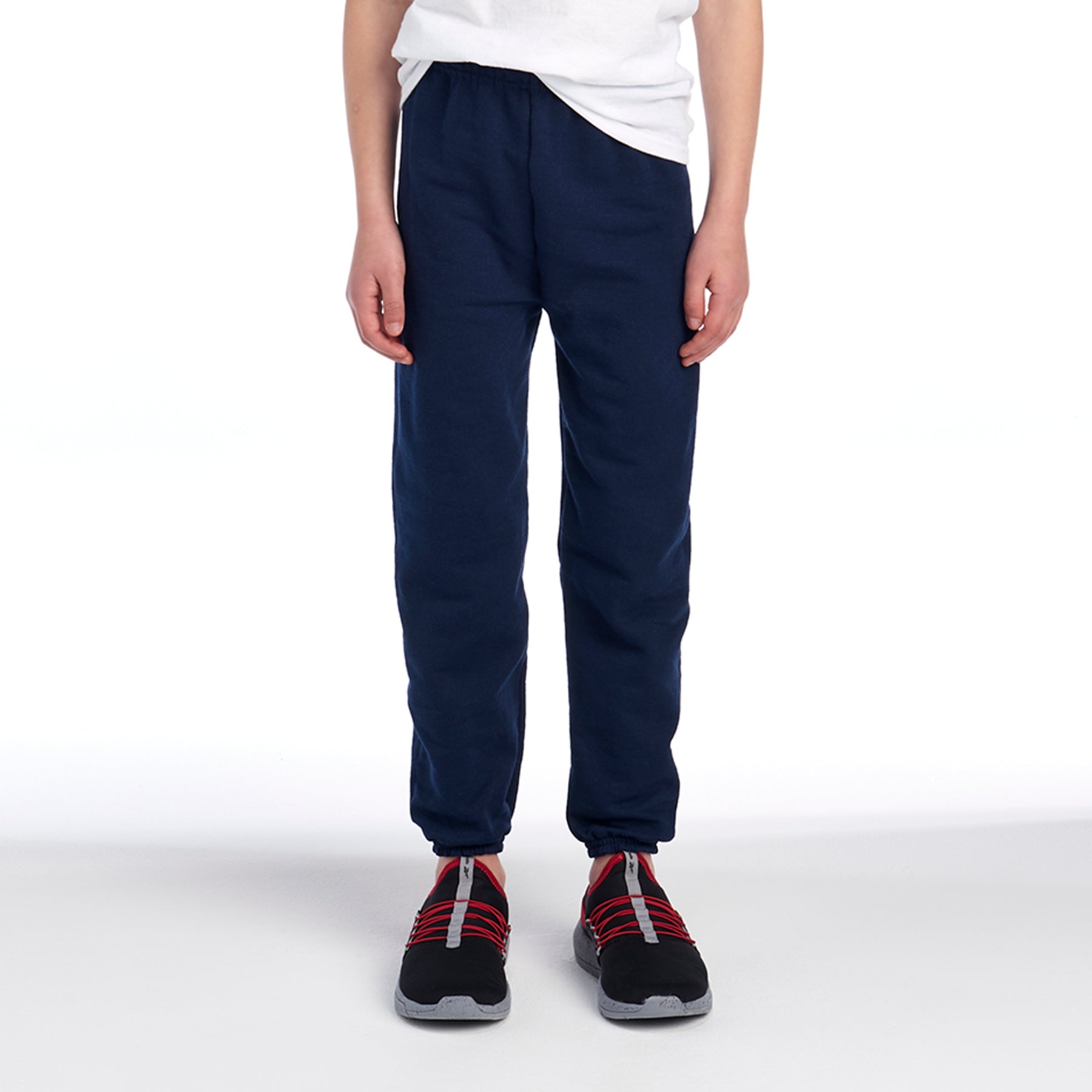 Youth model wearing Jerzees NuBlend youth sweatpants in J. Navy paired with a white t-shirt and athletic sneakers.
