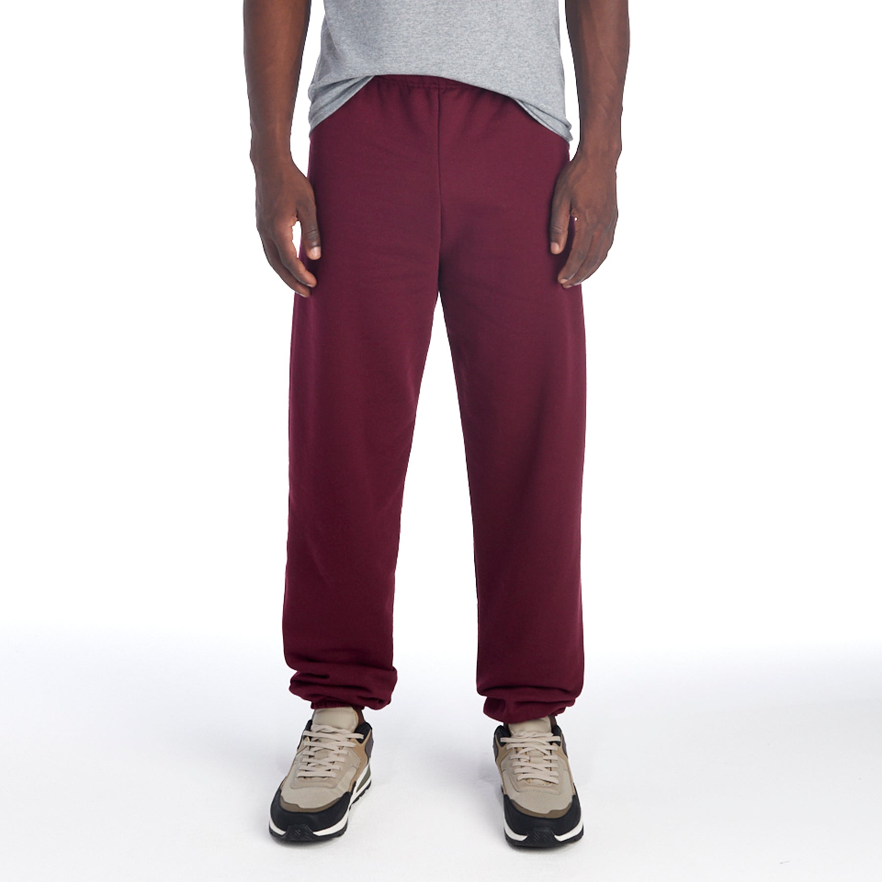 A model wearing Jerzees NuBlend Adult Sweatpants in maroon with neutral-colored sneakers.