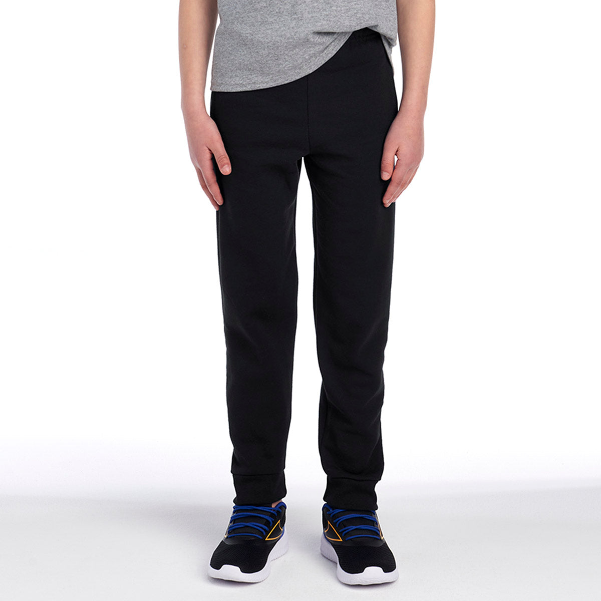 Youth wearing black Jerzees NuBlend® Pocketed Jogger Sweatpants with a gray t-shirt and athletic sneakers.