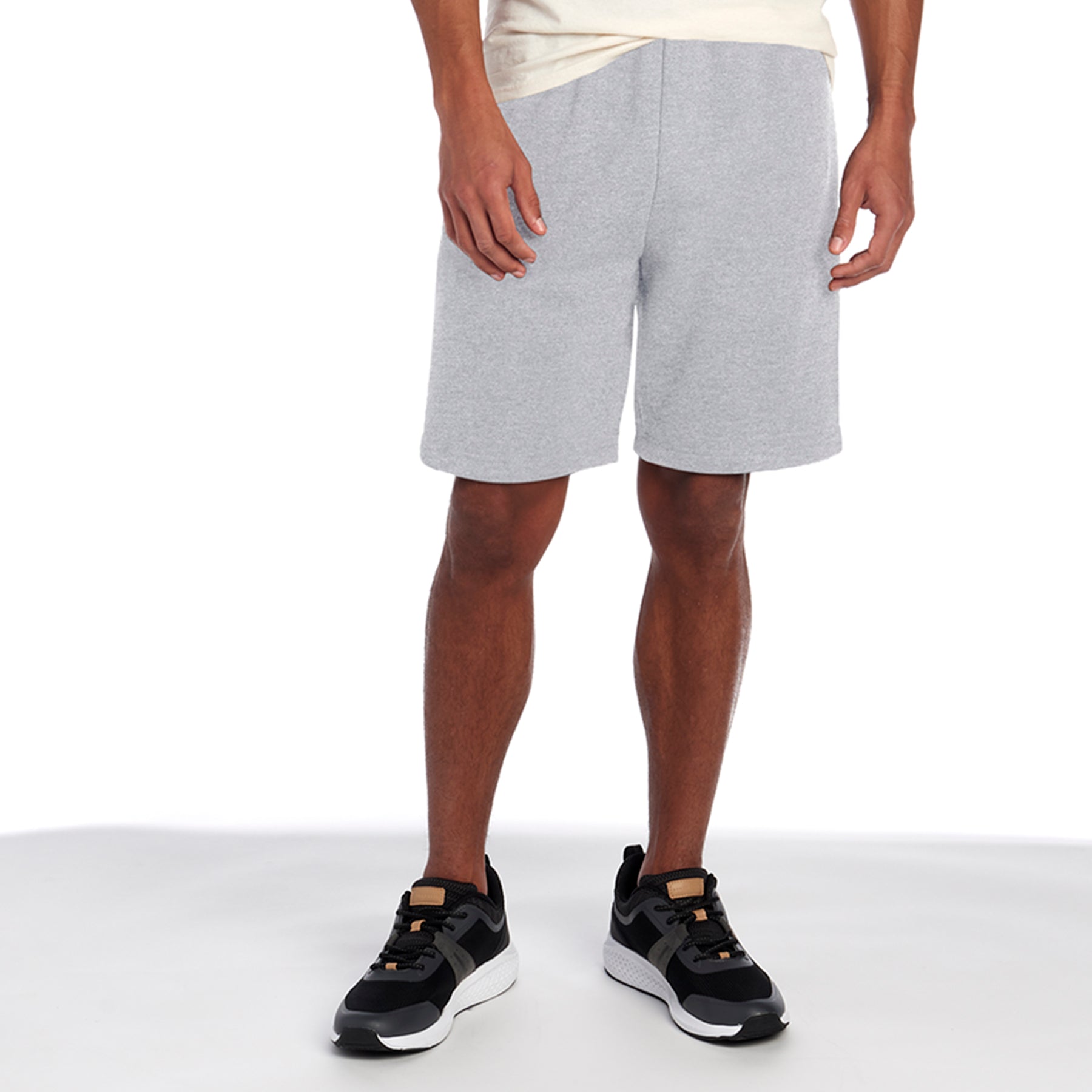 Model wearing athletic heather Jerzees NuBlend® Pocketed Sweat Shorts with black and white sneakers.