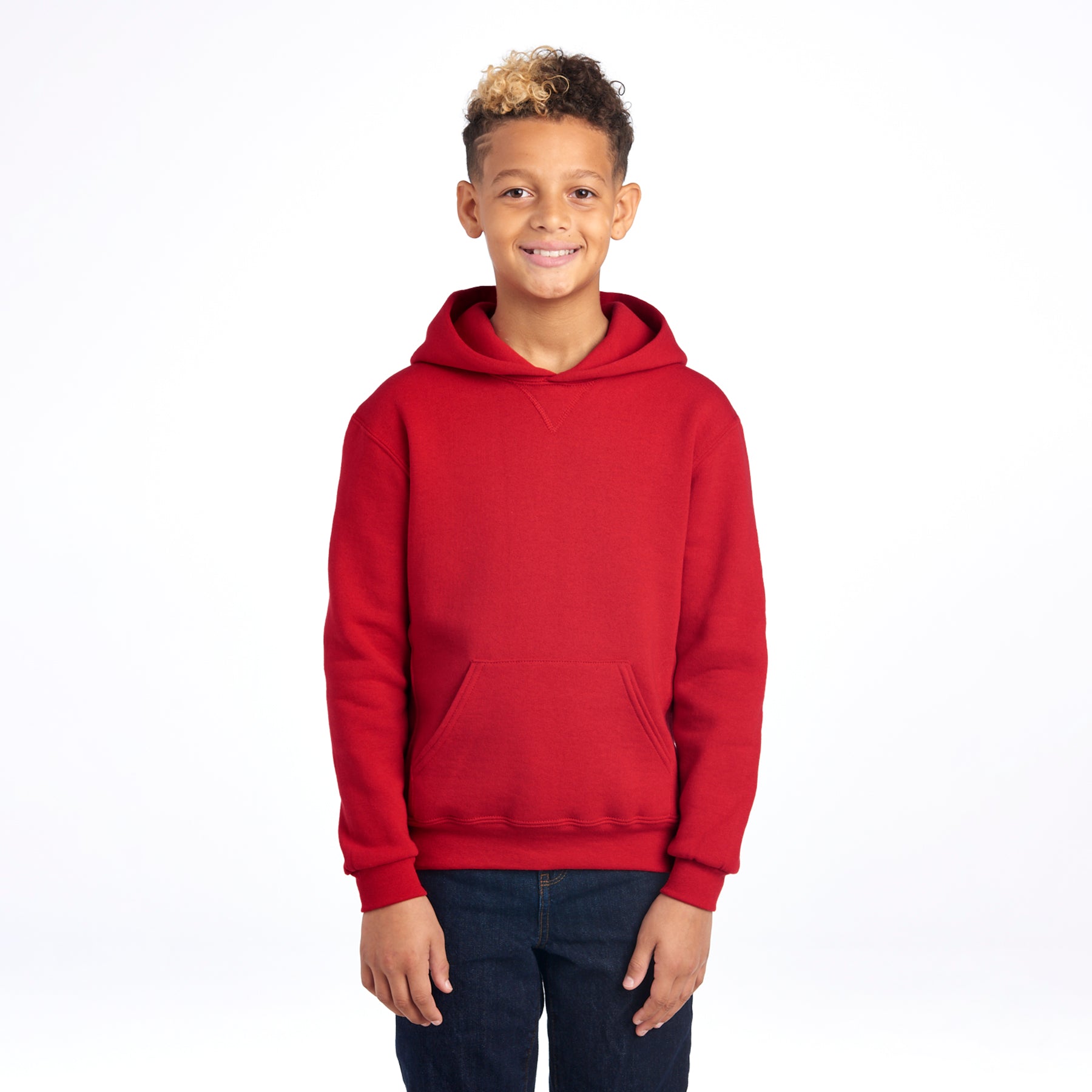 A young boy wearing a True Red Russell Athletic DRI-POWER Youth Fleece Pullover Hoodie, isolated on a white background.