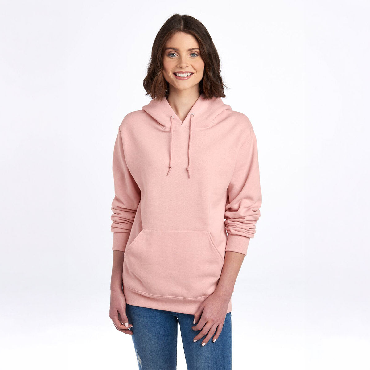 Woman wearing a blush pink Jerzees NuBlend Unisex Hooded Sweatshirt against a white background.