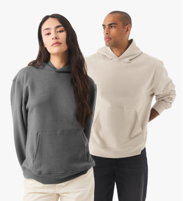 A woman wearing a charcoal grey hoodie and a man wearing a beige hoodie posing together.