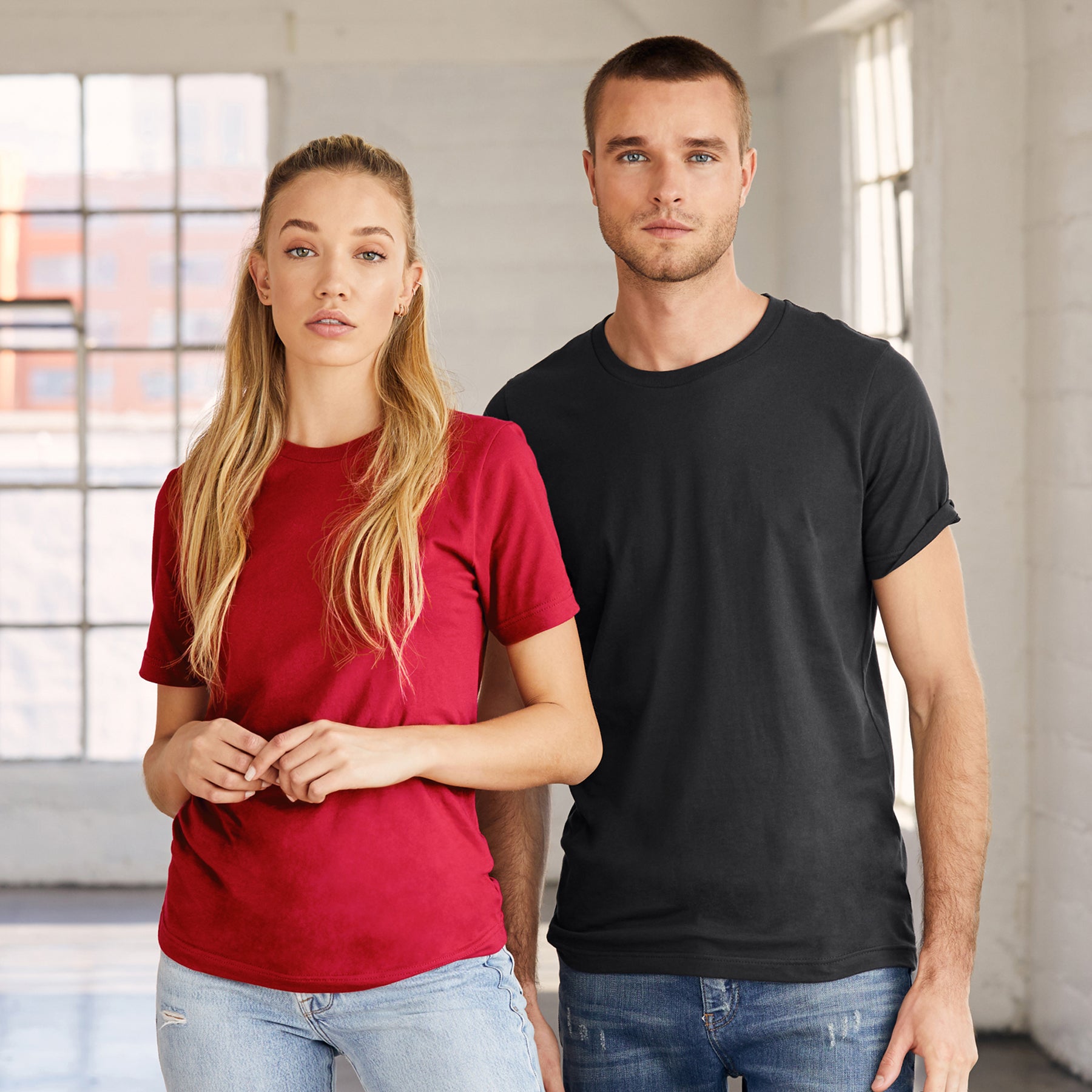 A man and woman modeling the Bella+Canvas Unisex Jersey Short Sleeve Tee in dark grey.