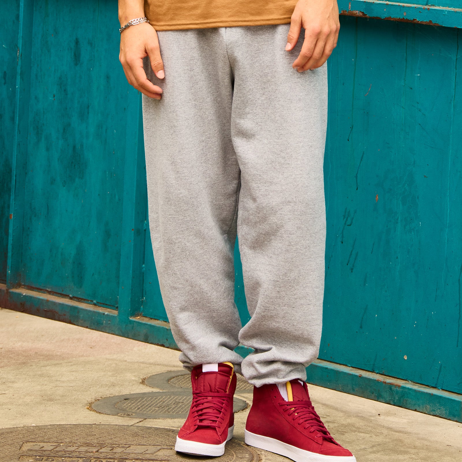 Jerzees NuBlend® adult sweatpants in Oxford grey, modeled with red high-top sneakers.