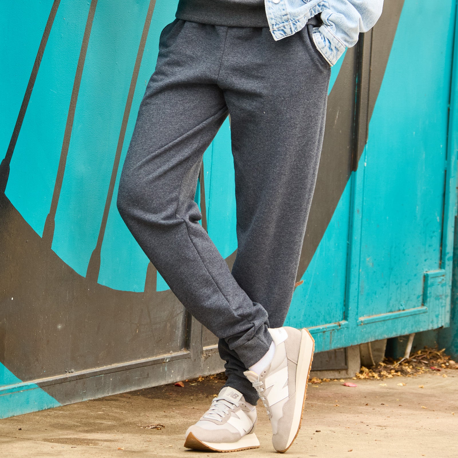 Jerzees NuBlend Adult Pocketed Jogger Sweatpants in Black Heather, styled with a denim jacket and grey sneakers.
