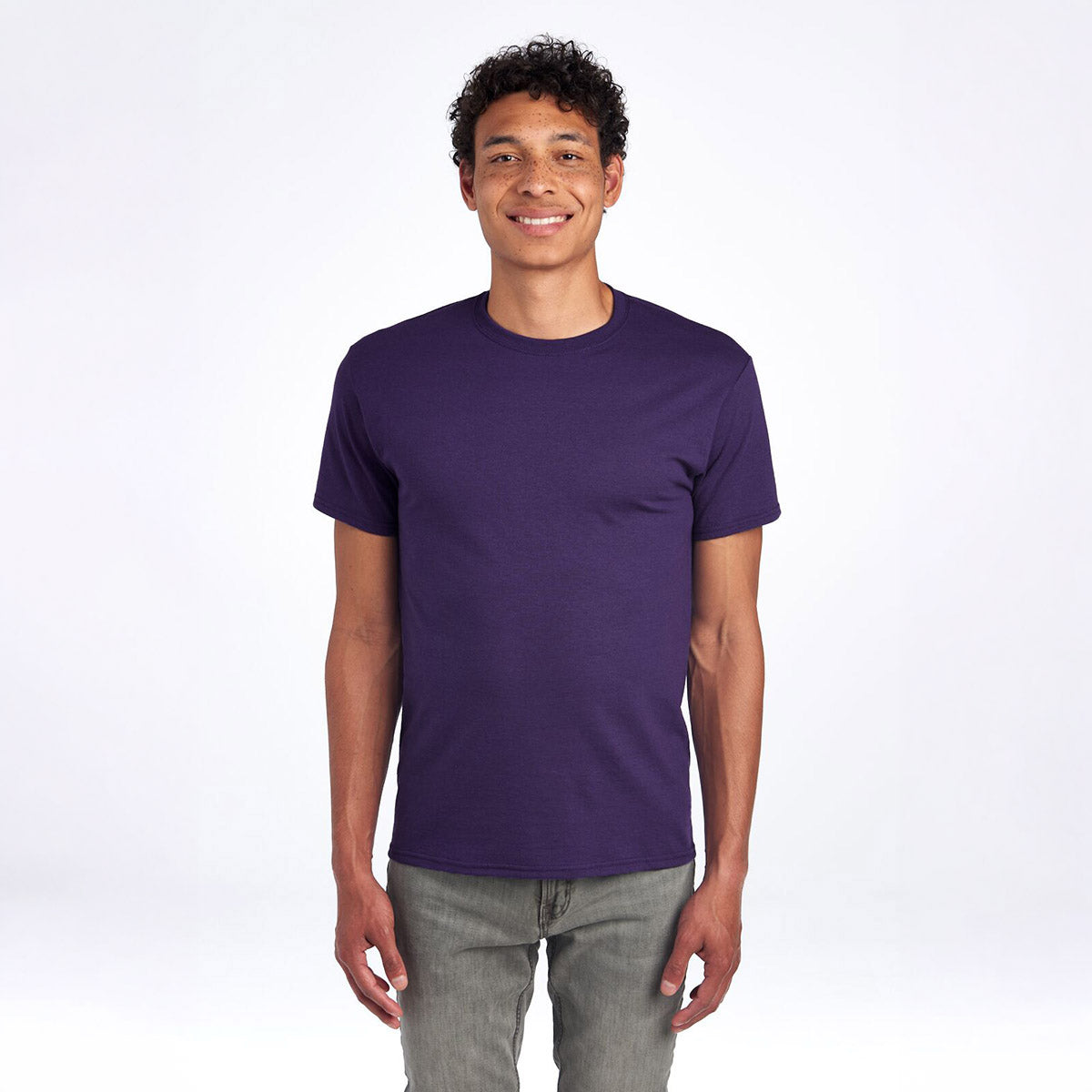 A man wearing a deep purple Jerzees Dri-Power Unisex T-Shirt against a plain white background.