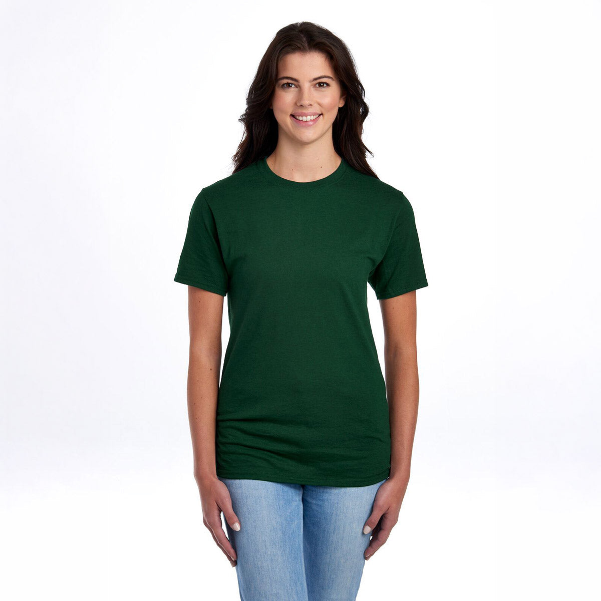 Smiling woman wearing a forest green Jerzees Dri-Power unisex crewneck t-shirt and blue jeans against a white background.