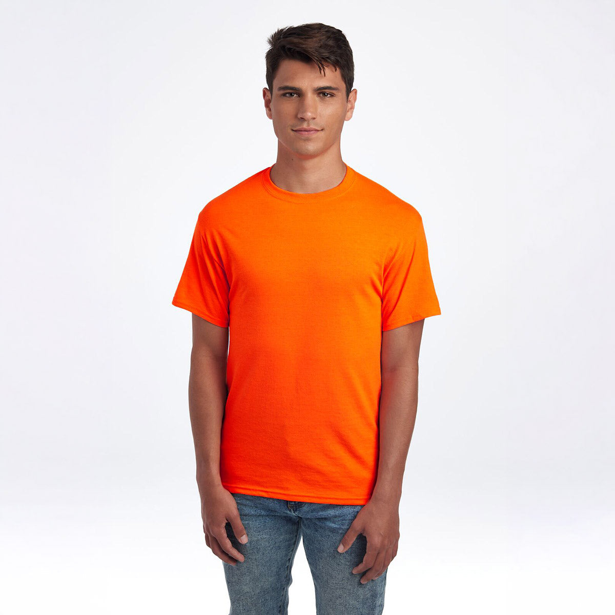 Man wearing a Jerzees Dri-Power Unisex T-Shirt in safety orange, paired with blue jeans, against a white background.
