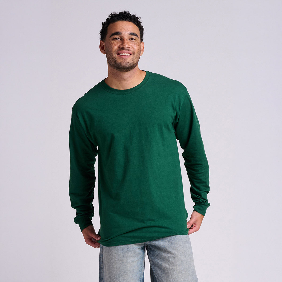 Smiling man wearing a Jerzees Classics Unisex Long Sleeve t-shirt in forest green.