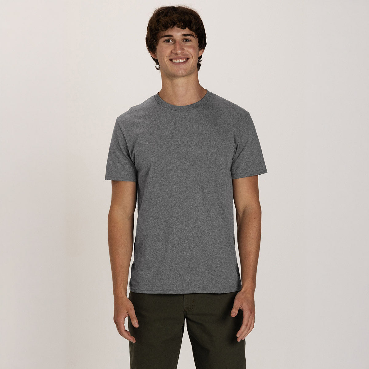 Young man wearing a Graphite Heather Jerzees Classics unisex crewneck T-shirt against a plain white background.