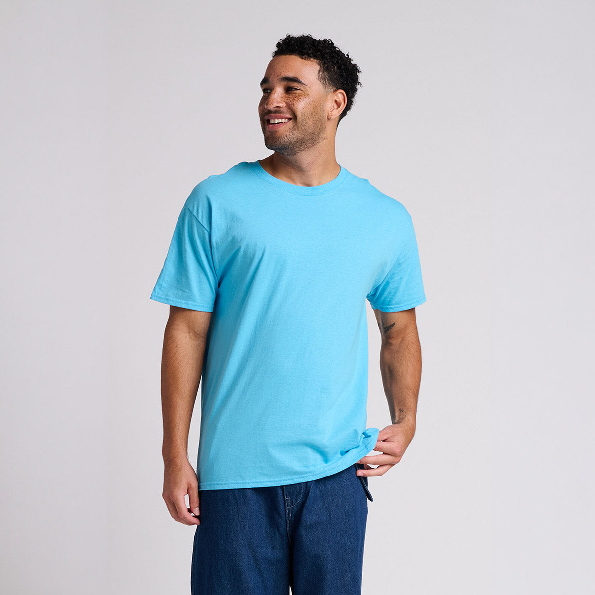 Jerzees Classics unisex T-shirt in aquatic blue, worn by a smiling man against a white studio background.