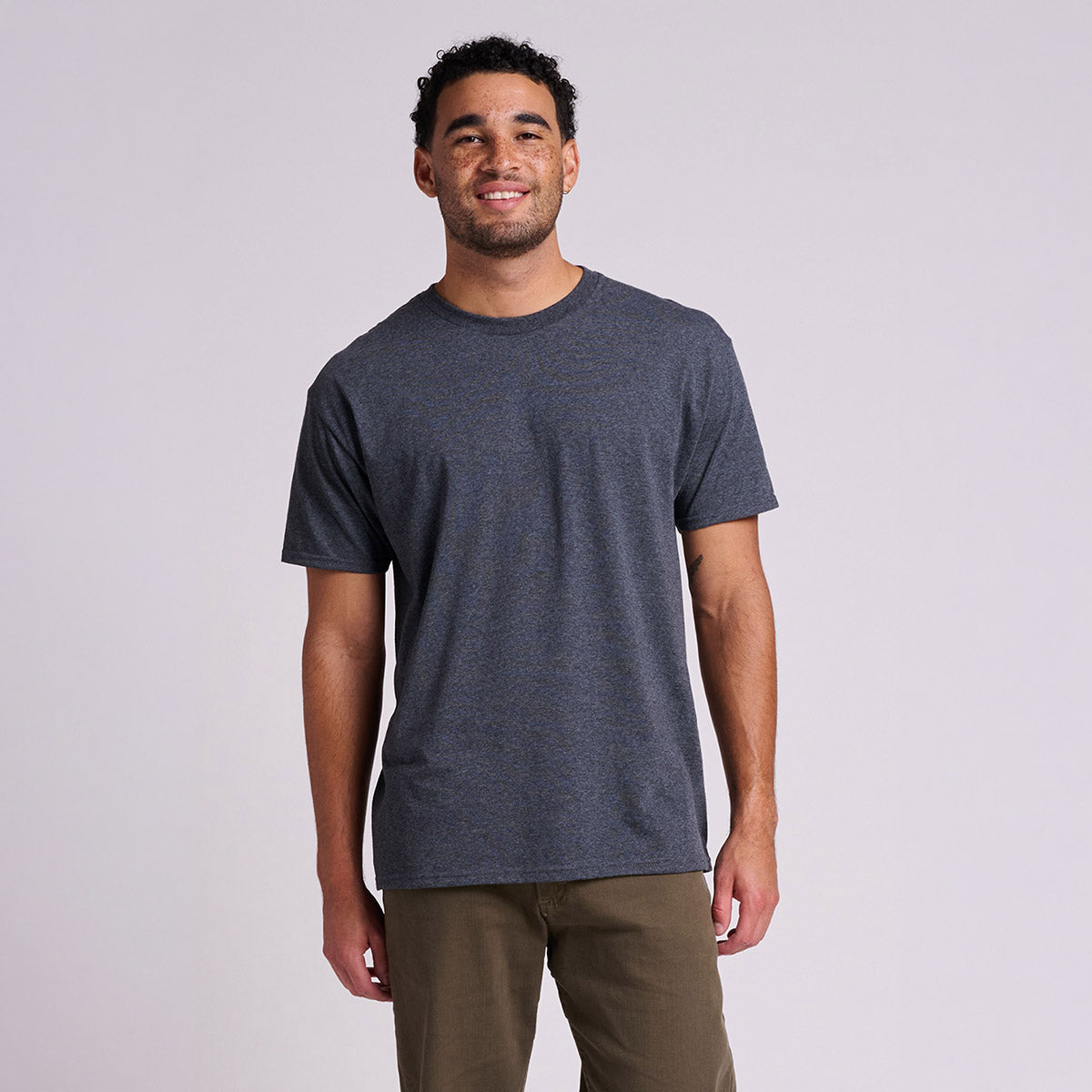 A man wearing a Jerzees Classics Unisex T-Shirt in black heather against a plain white background.