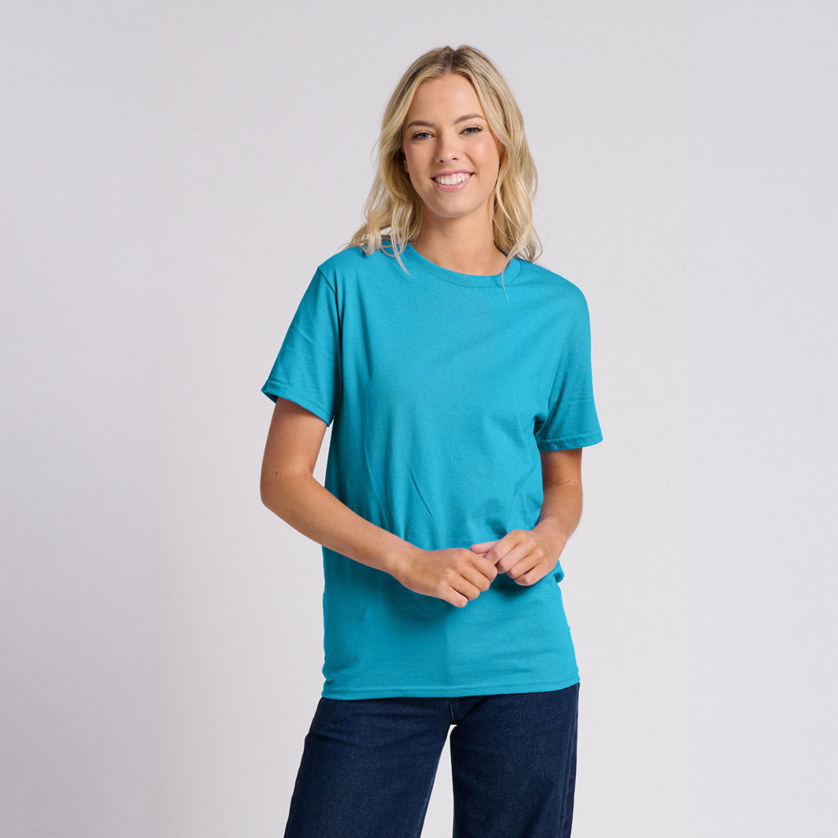 A blonde woman wearing a California Blue Jerzees Classics unisex T-shirt against a light gray background.