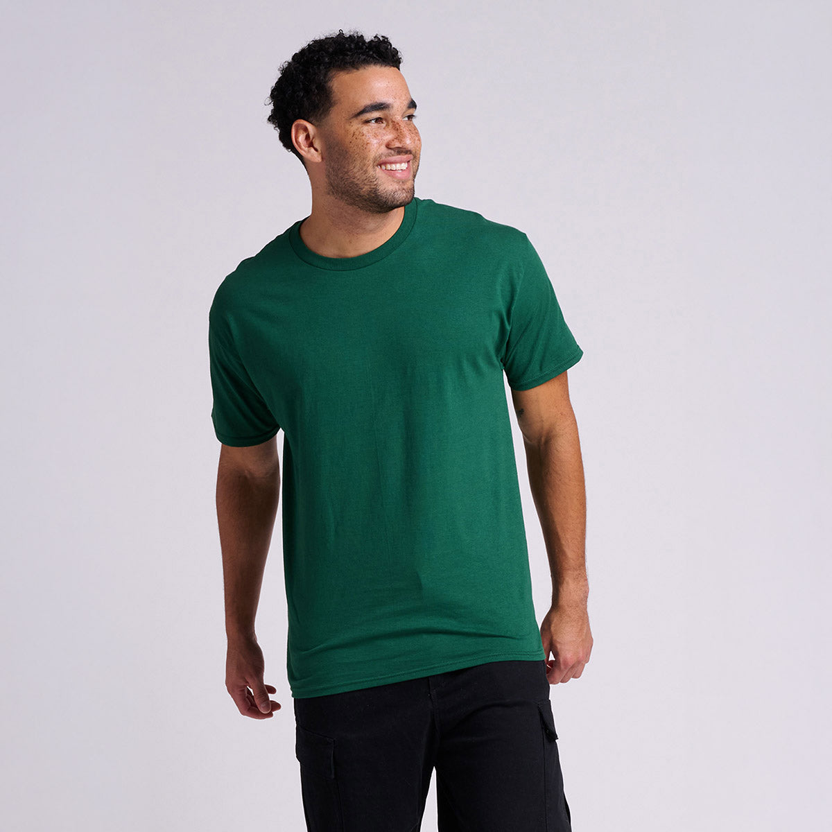 A man wearing a Jerzees Classics unisex T-shirt in forest green.