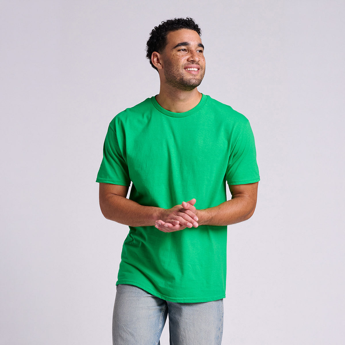 A man wearing a green Jerzees Classics unisex t-shirt in Kelly color, captured from the waist up.