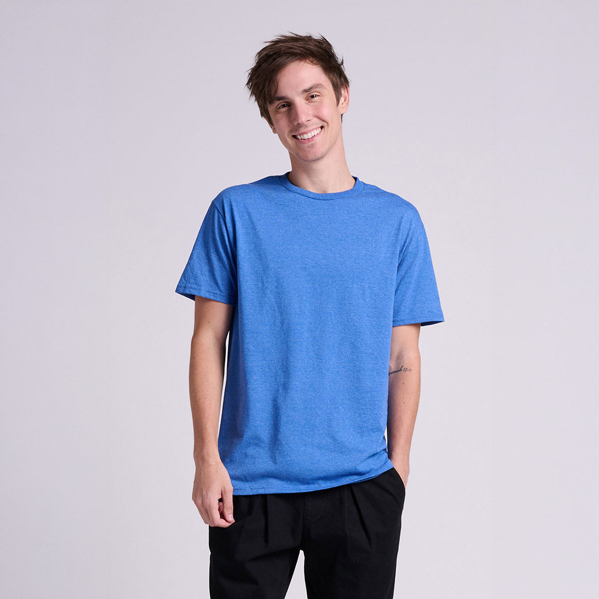 A smiling man wearing a Jerzees Classics unisex t-shirt in retro heather royal blue.