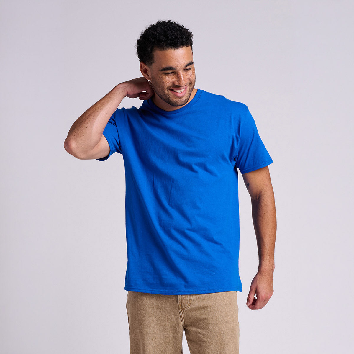 Man wearing a Jerzees Classics Unisex T-Shirt in royal blue color, standing against a light gray background.