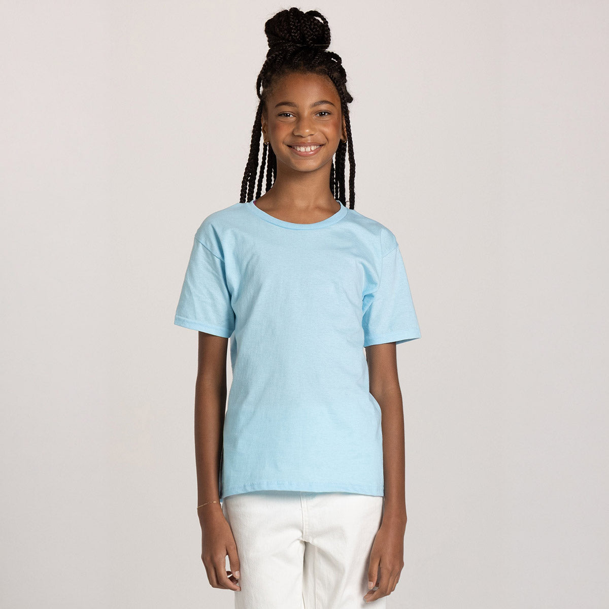 A young girl smiling while wearing a Breezy Blue Jerzees Classics youth t-shirt.
