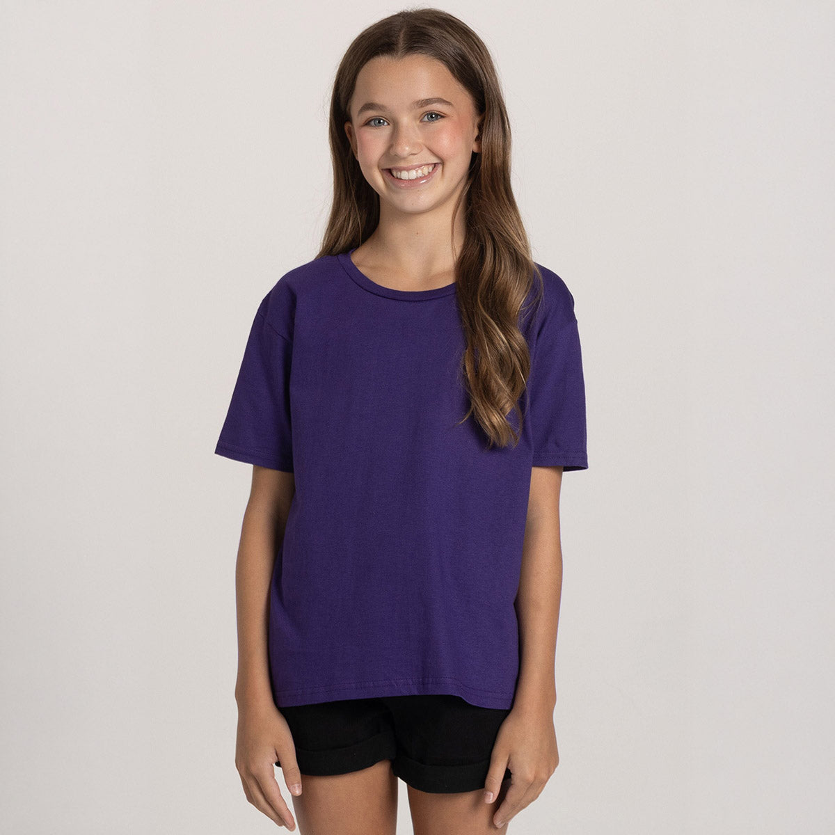 Young girl wearing a deep purple Jerzees Classics youth T-shirt against a plain background.