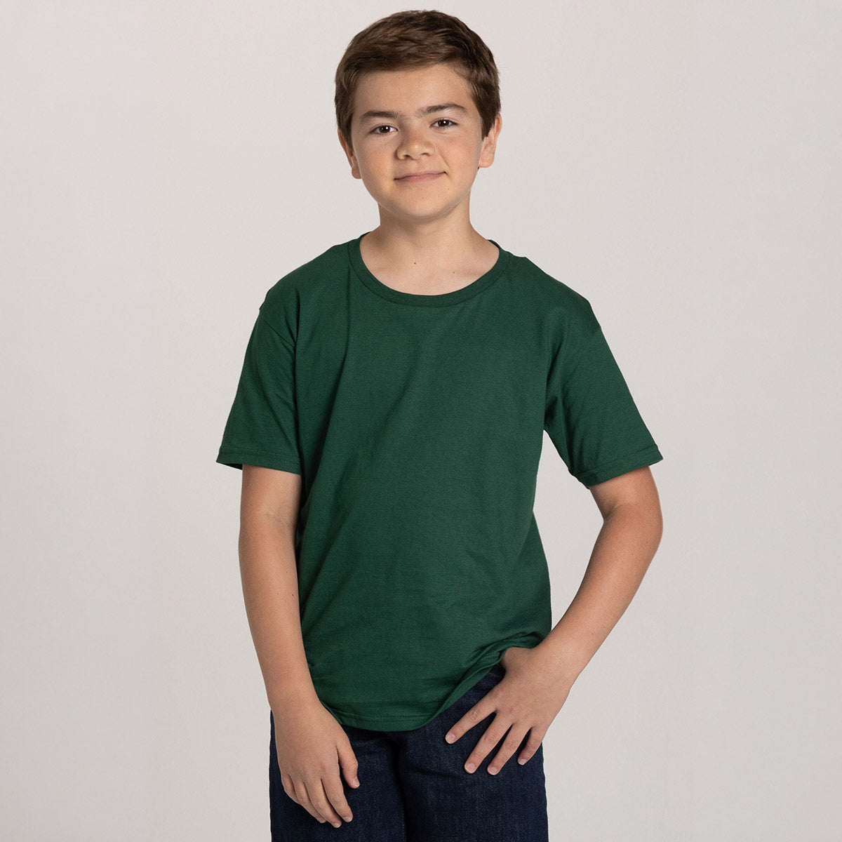 A young boy modeling a forest green Jerzees Classics Youth T-Shirt against a plain background.
