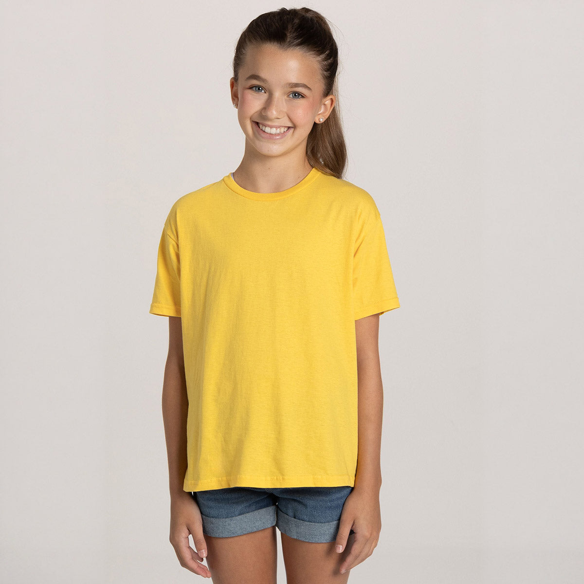 A young girl wearing an Island Yellow Jerzees Classics Youth T-Shirt against a neutral background.