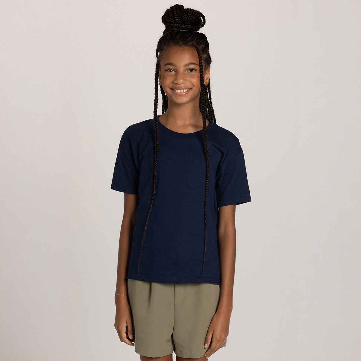 A young girl smiling while wearing a navy blue Jerzees Classics Youth T-Shirt.