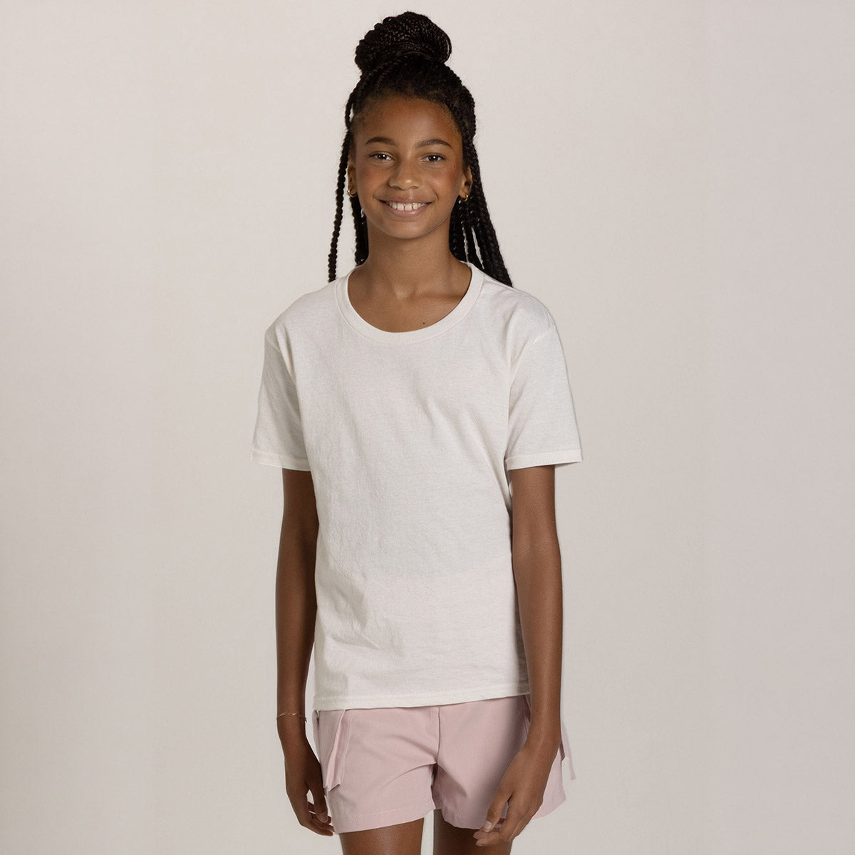 A young girl wearing a sweet cream heather Jerzees Classics Youth T-Shirt against a studio background.
