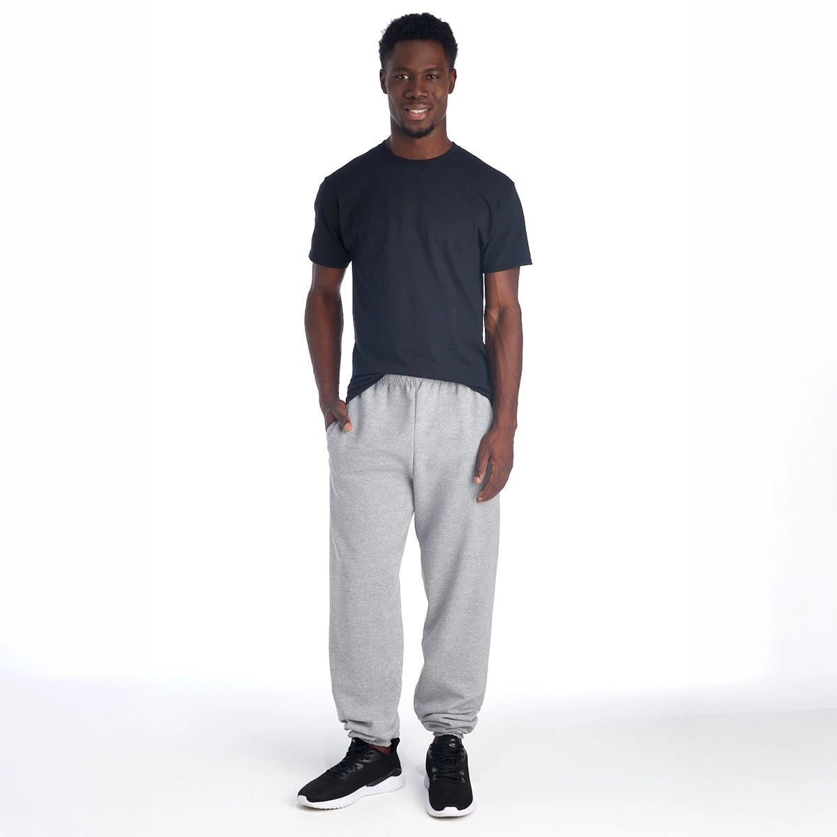 Model wearing Jerzees Super Sweats® NuBlend® Pocketed Sweatpants in Oxford gray with a black t-shirt.